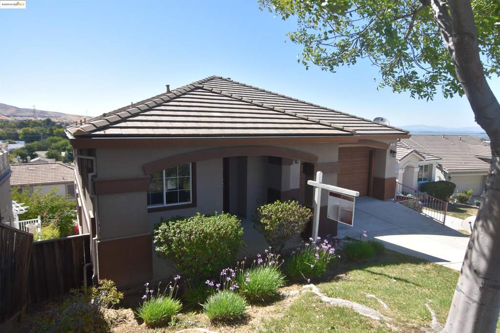 View of front of house featuring a tiled roof, driveway, a mountain view, and a garage at 127 Delta Vista Ln, Pittsburg, CA 94565