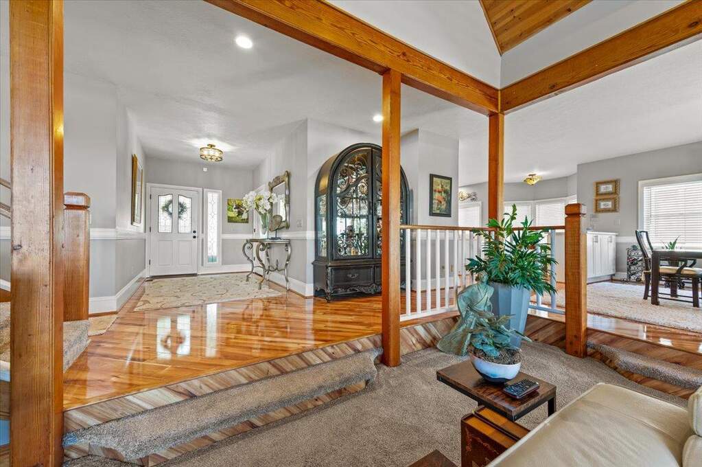 The gorgeous, warm wood floors in the entry lead to a stunning open beam living room with high ceilings and amazing views! at 12064 Waxwing Court, Penn Valley, CA 95946